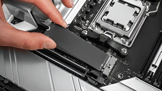 A person is installing an M.2 NVMe SSD into a modern motherboard socket, showcasing computer hardware assembly in progress.