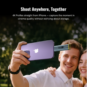 Person holding a smartphone with a camera attachment, outdoors.